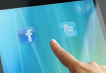 Manos sujetando una tablet con los logos de facebook y twitter
