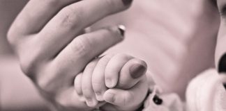 mano de un bebe cogiendo el dedo de la mano de una mujer