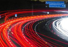 fotografia de una carretera de noche y coches pasando