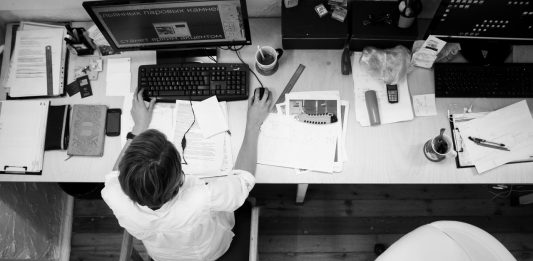 hombre con camisa blanca en una oficina blanca trabajando con el ordenador
