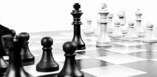 figuras del rey de ajedrez blanca y negra enfrentadas en un tablero de ajedrez