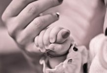 mano de un bebe cogiendo el dedo de la mano de una mujer