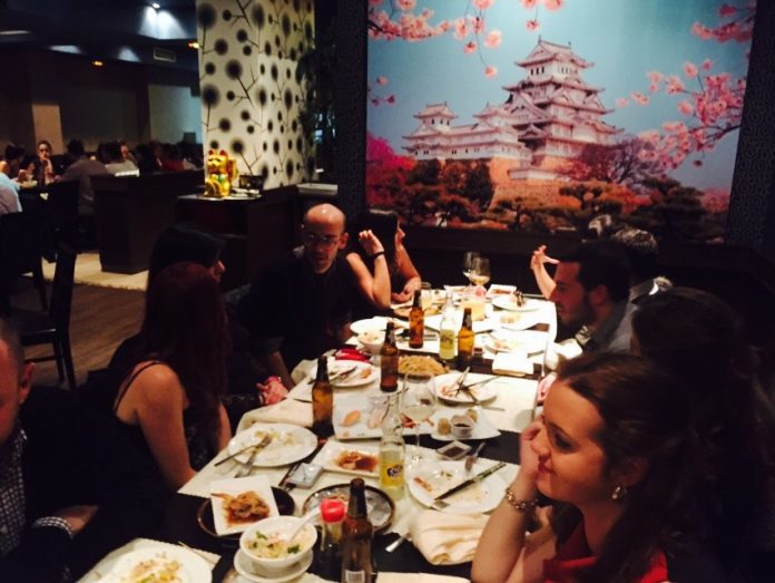 grupo de personas en un restaurante chino hablando mientras cenan