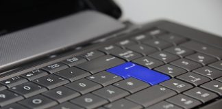 tecla de enter de color azul en un teclado negro de un ordenador