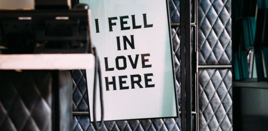 "i fell in love here" cartel colgado en una oficina