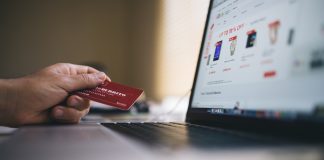 mano de una persona sujetando una tarjeta de credito para pagar una compra online