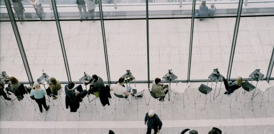 Как рекрутер вы полюбите 3 новые функции Zoho Recruit gente almorzando en una cafeteria con grandes ventanales