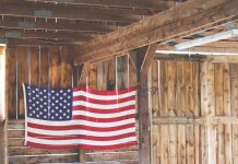 Bandera de Estados Unidos de tela grande colgada en una pared de madera