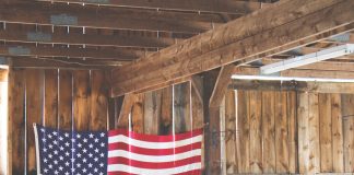 Bandera de Estados Unidos de tela grande colgada en una pared de madera